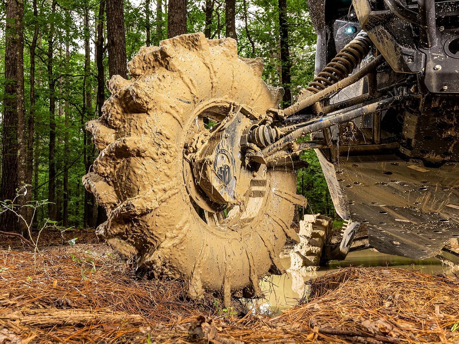 Assassinator tire packed with tan clay, the tall lugs still standing out of the mud coating the casing